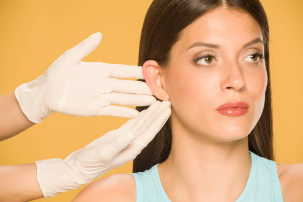 doctor showcasing womans ear before otoplasty surgery
